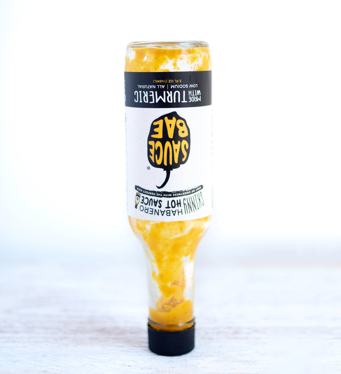 An empty bottle of Sauce Bae turned upside down