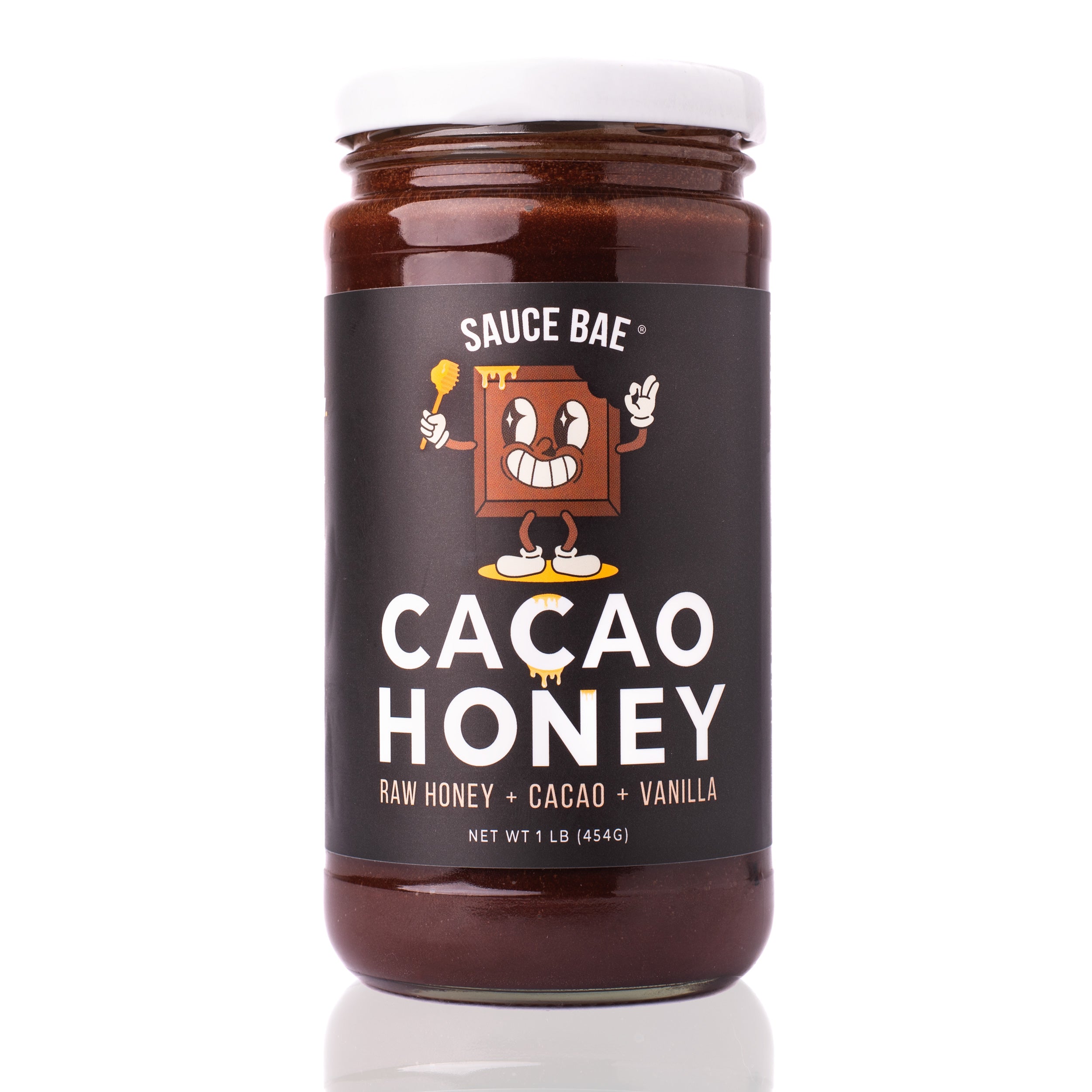 Front view of a 1-pound jar of Sauce Bae Cacao Honey, featuring a cartoon chocolate character on a black label with the text “Cacao Honey – Raw Honey + Cacao + Vanilla.