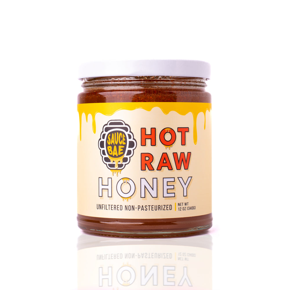 12 oz Sauce Bae Hot Raw Honey jar placed on a white backdrop, 'Unfiltered Non-Pasteurized' text.