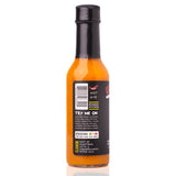Side view of Sauce Bae Hotter Habanero Hot Sauce bottle featuring a heat rating of 6/10, barcode, and suggested food pairings like avocado toast, burgers, tacos, and salmon. Text highlights a flavor profile of habanero and ghost pepper with a hint of sweetness. Branding includes "The Only Bae You Need" and refrigeration note. Displayed on a clean white background.