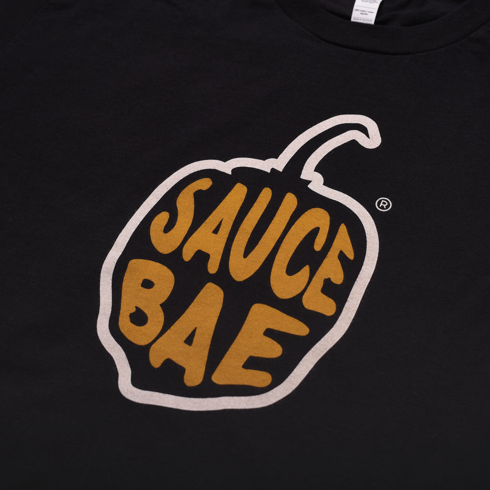 Close up view of Black Sauce Bae tee with Pepper logo on the chest.