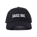 Black dad hat with white embroidered 'Sauce Bae' logo on the front. Perfect for fans of Sauce Bae, a health-focused hot sauce and raw honey brand