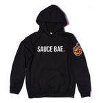 Front view of Sauce Bae black hoodie featuring Sauce Bae logo on chest and pepper logo on left sleeve. High-quality, cozy fabric.